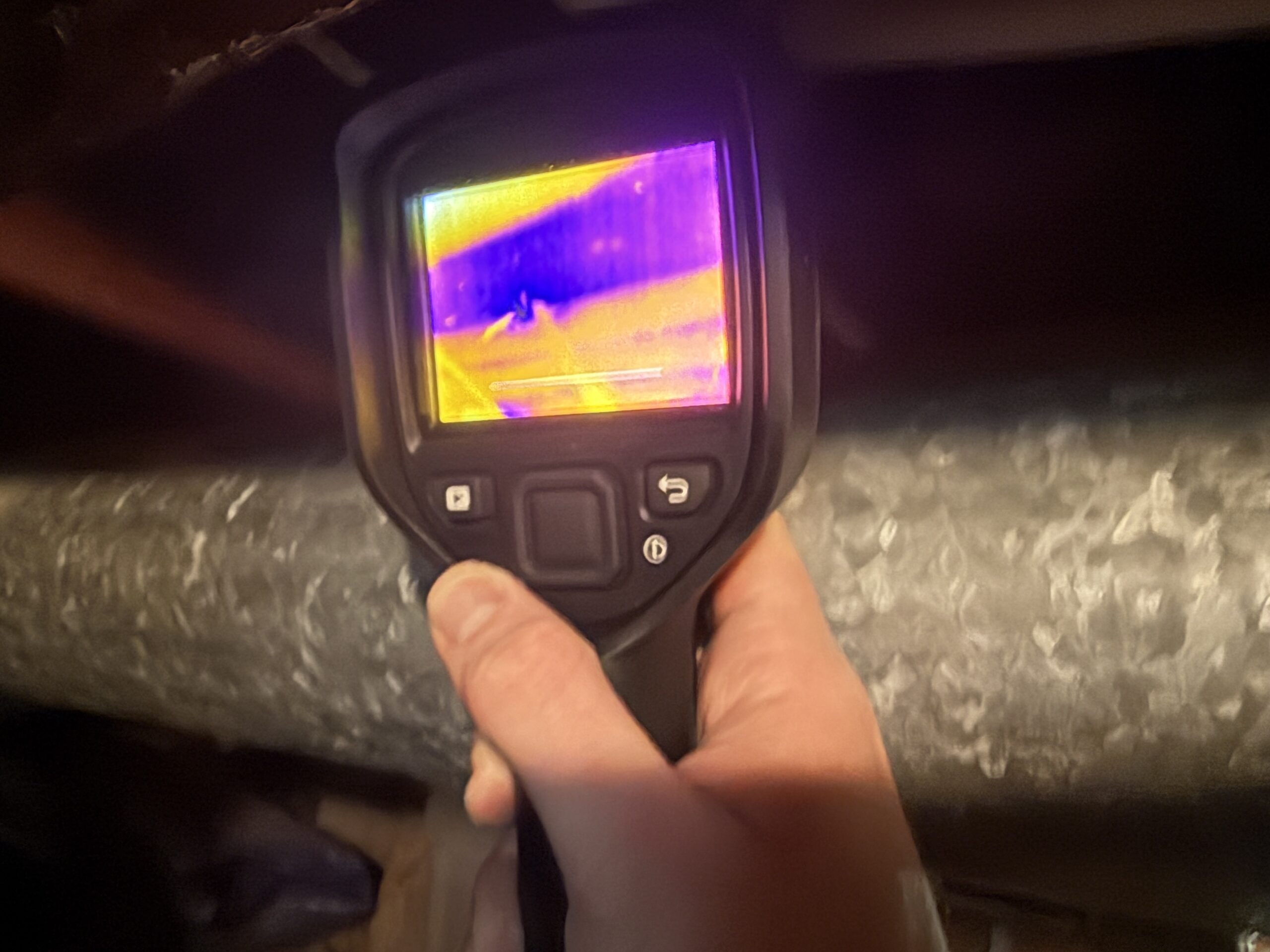 Thermal imaging camera showing a moisture pattern behind a wall