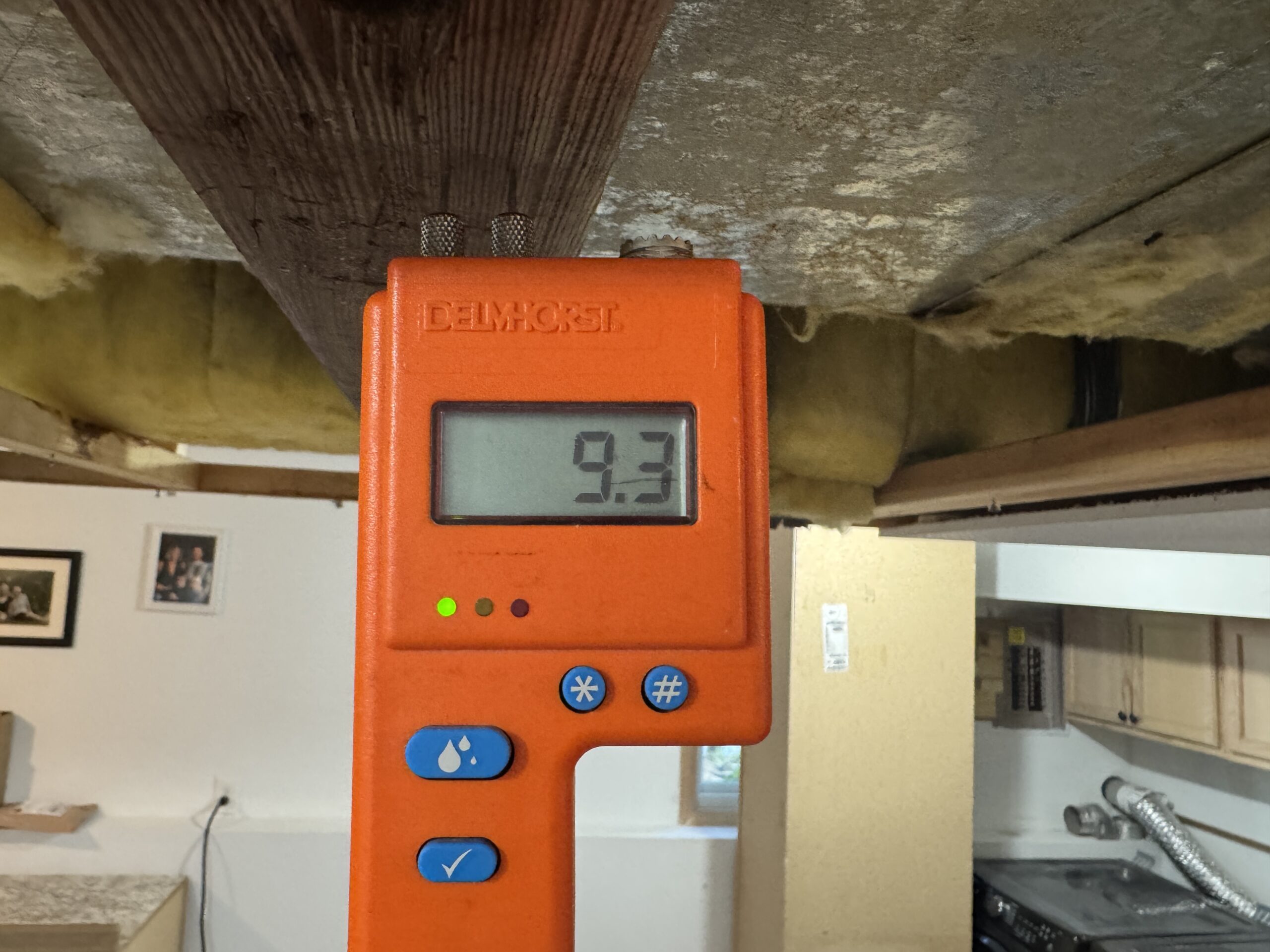 Moisture meter displaying a reading in a room with the ceiling opened